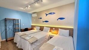 Quarto de hotel com duas camas, uma escrivaninha e um guarda-roupa.