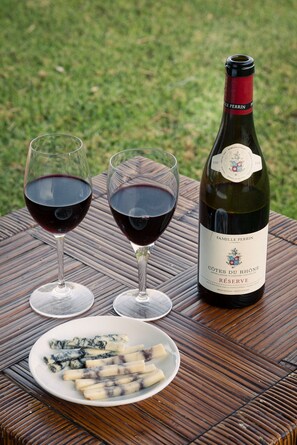 A bottle of wine and two glasses on a table with a plate of cheese. - Almagor House (Emek HaYarden)