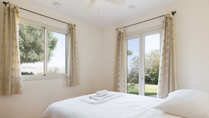 Une chambre à coucher avec un lit, une fenêtre et un ventilateur de plafond.