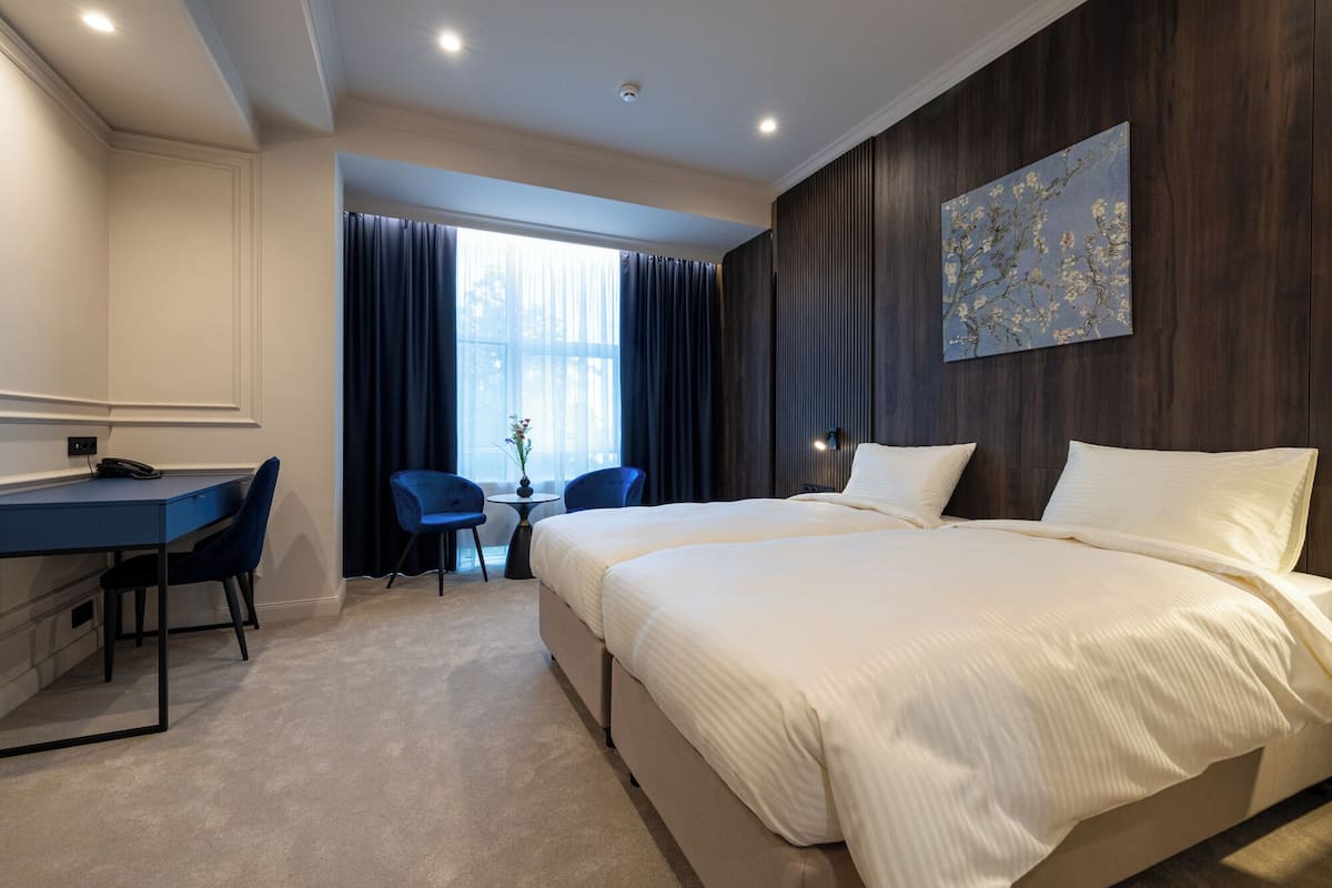 A hotel room with a bed, a desk, and a chair.