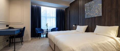 A hotel room with a bed, a desk, and a chair.