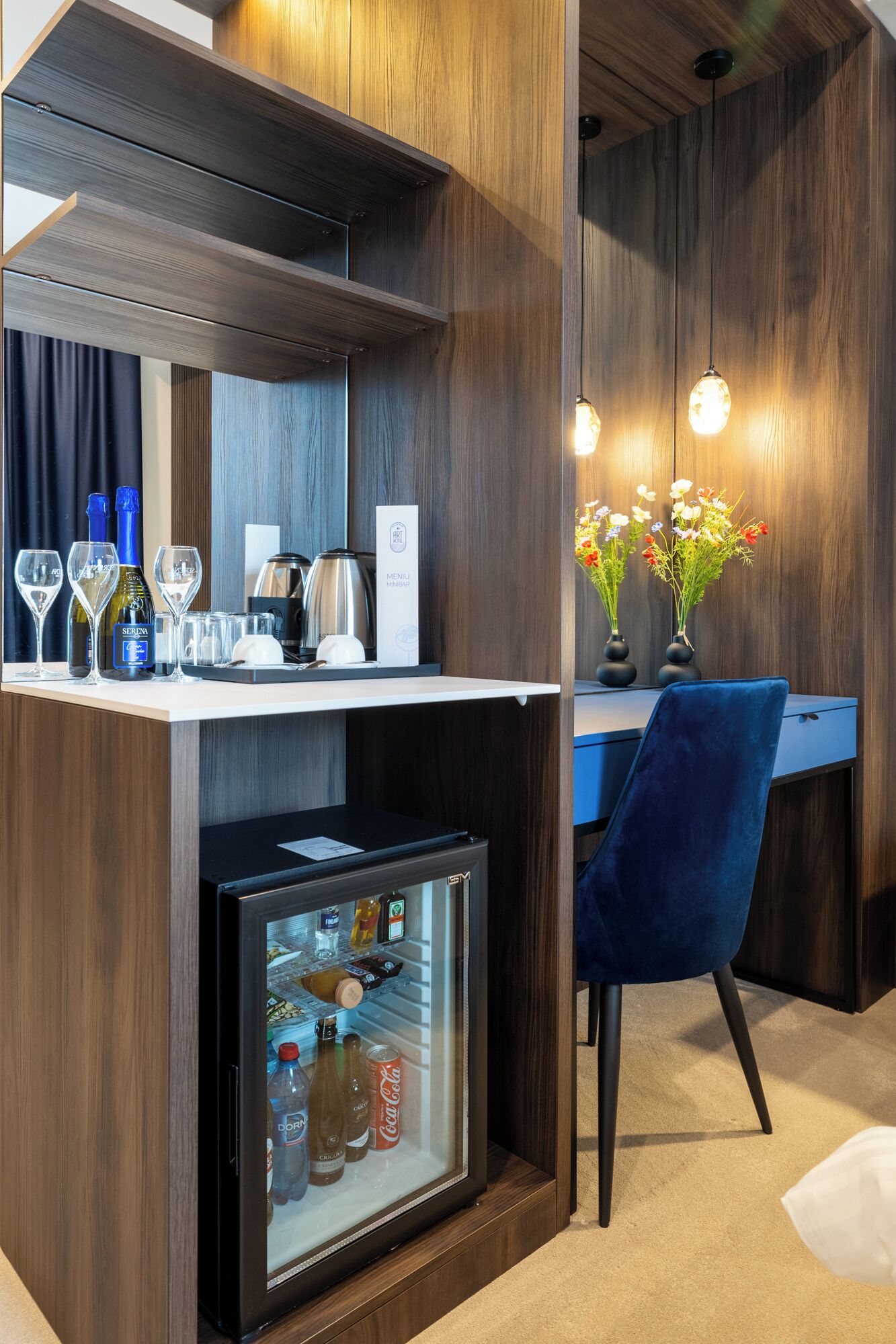 A compact bar area with a refrigerator stocked with beverages, a coffee maker, and a menu sign.