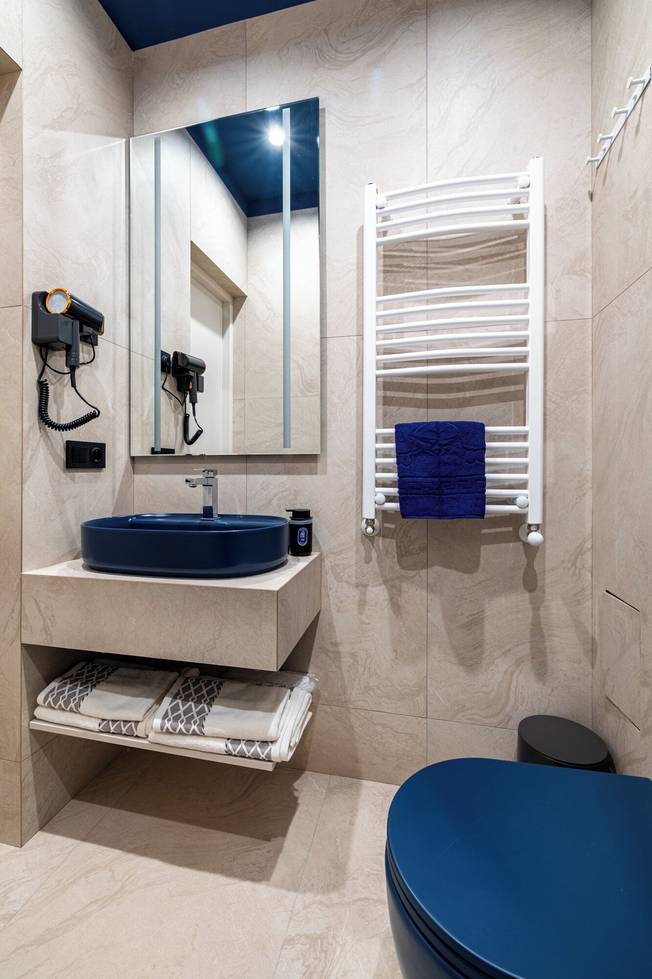 A modern bathroom with a built-in sink, a towel rack, and a mirror.