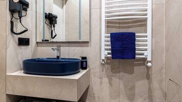 A modern bathroom with a built-in sink, a towel rack, and a mirror.