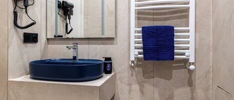 A modern bathroom with a built-in sink, a towel rack, and a mirror.