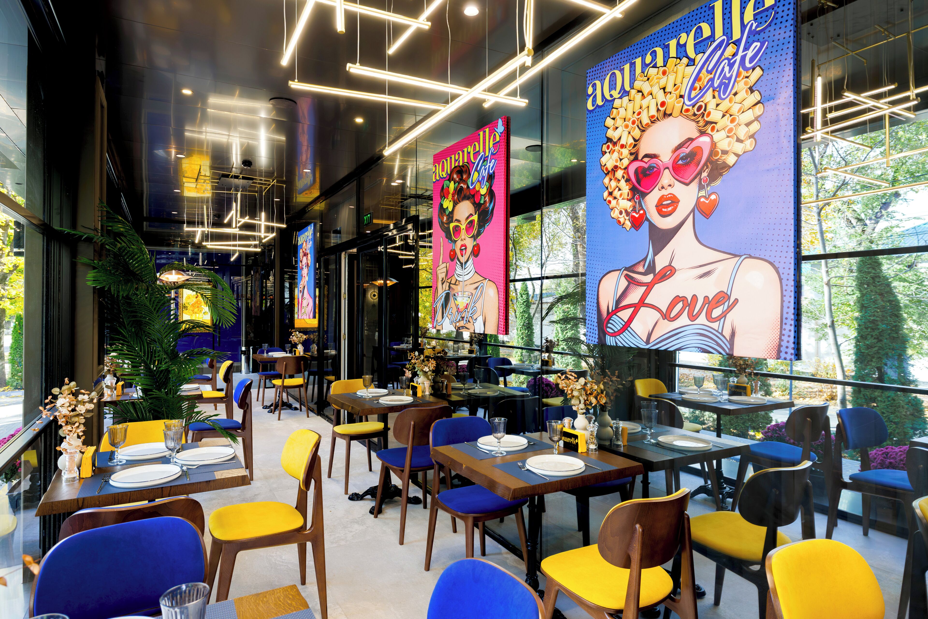 A restaurant with tables set for dining, chairs, and a large mural on the wall.