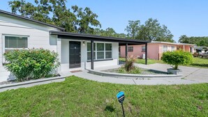 A single-story residential building with a front porch and a small garden area. - Heated Pool & Game Room, Sleeps 10 | 5 Min to Busch Gardens, Tampa (Tampa)