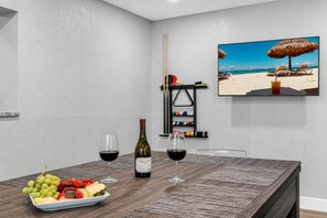Ein Essbereich mit Tisch für zwei Personen, inklusive Weinflasche, Gläsern und einer Obstplatte.