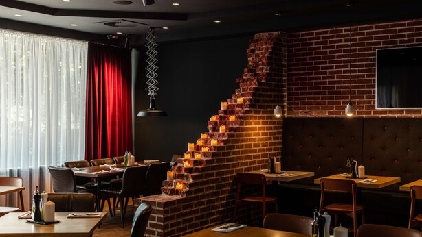 Ein Restaurant mit Ziegelwänden, Holztischen und -stühlen.