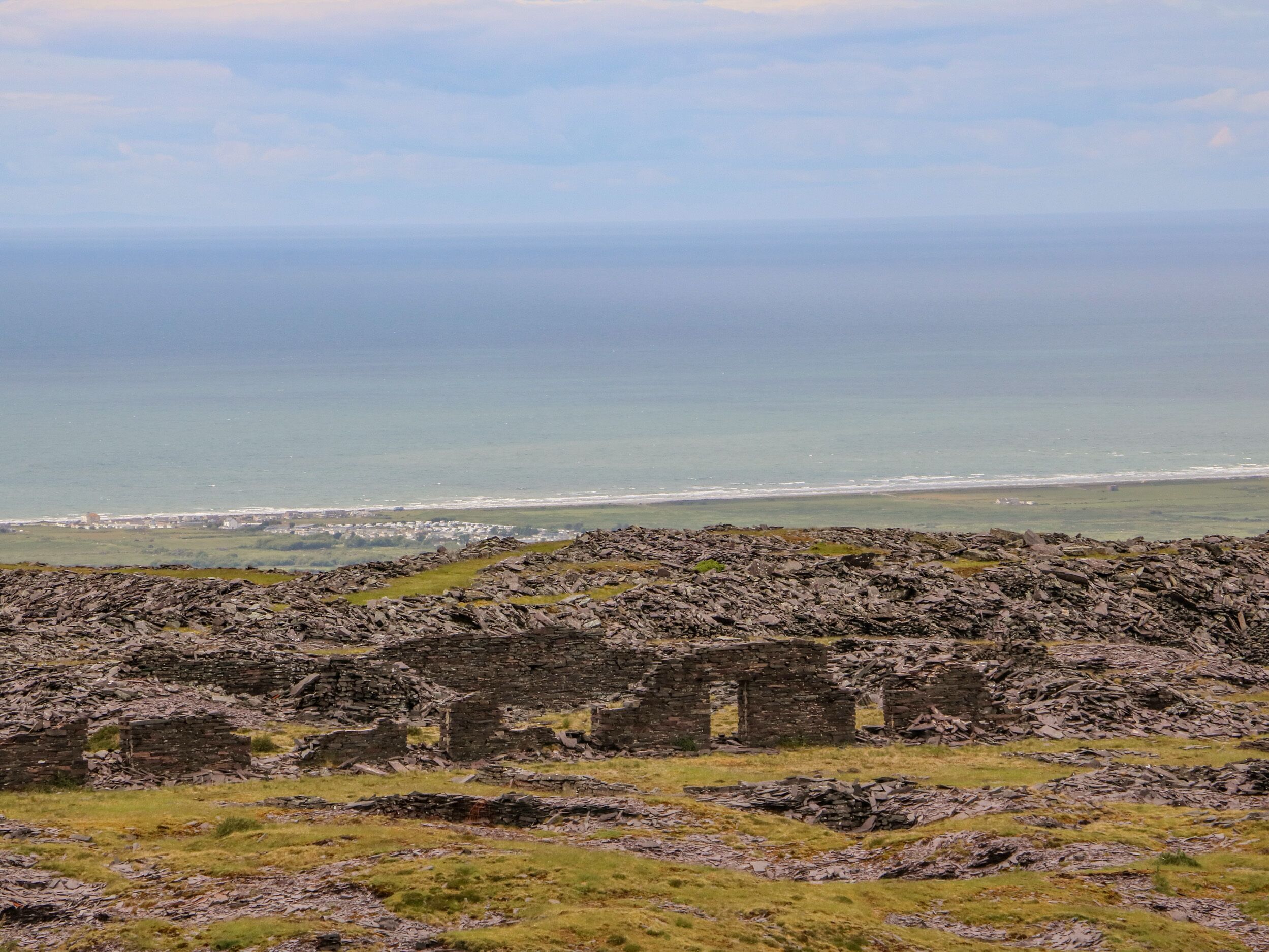 Paisaje costero con ruinas y vista al mar.