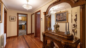 A hallway with wooden flooring, a grand mirror, and a chandelier. - Plaza berri - baskeyrentals (Azkoitia)