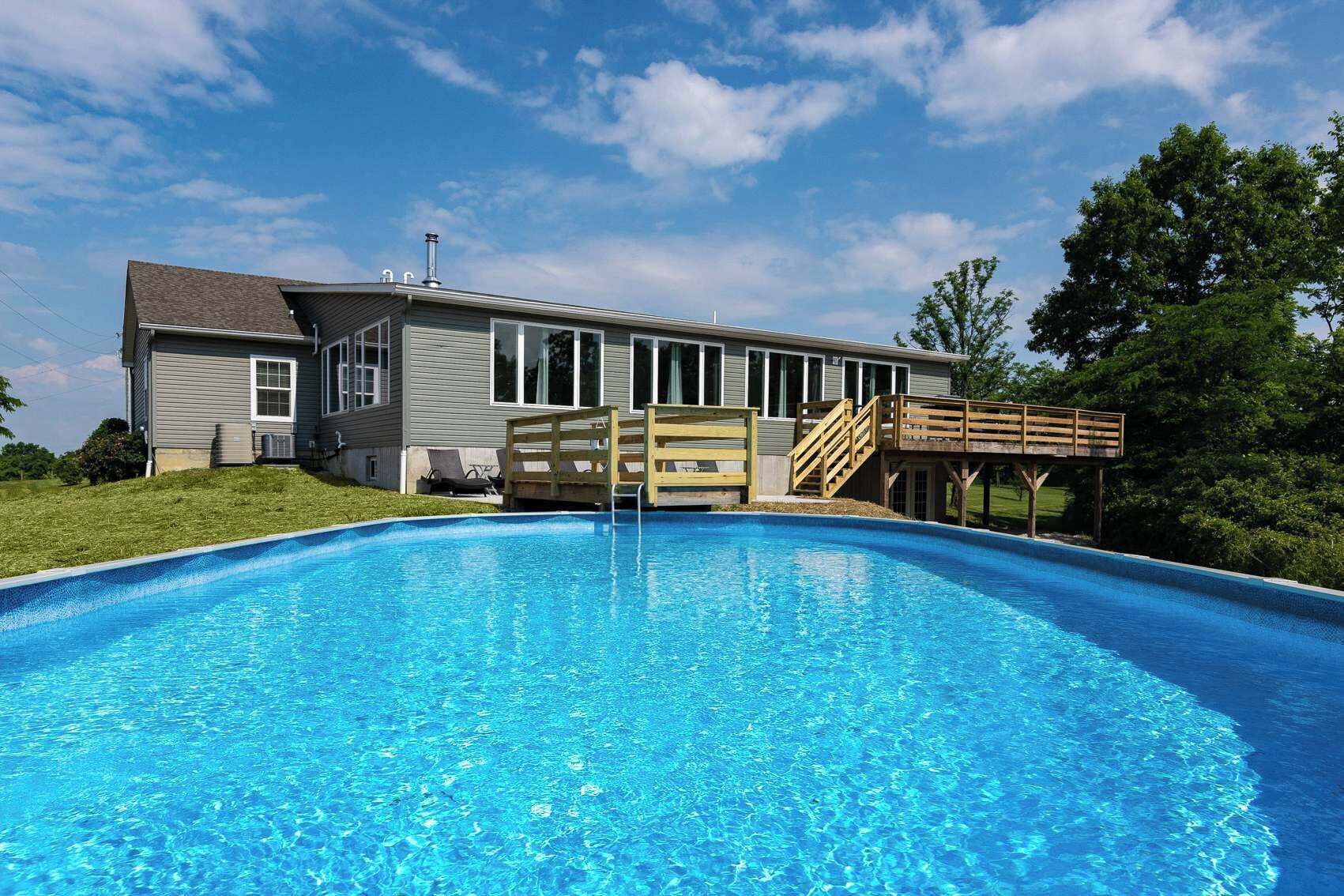 A residential swimming pool with a house in the background.