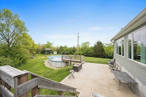 Un jardin avec une piscine, des meubles de patio et une terrasse en bois.