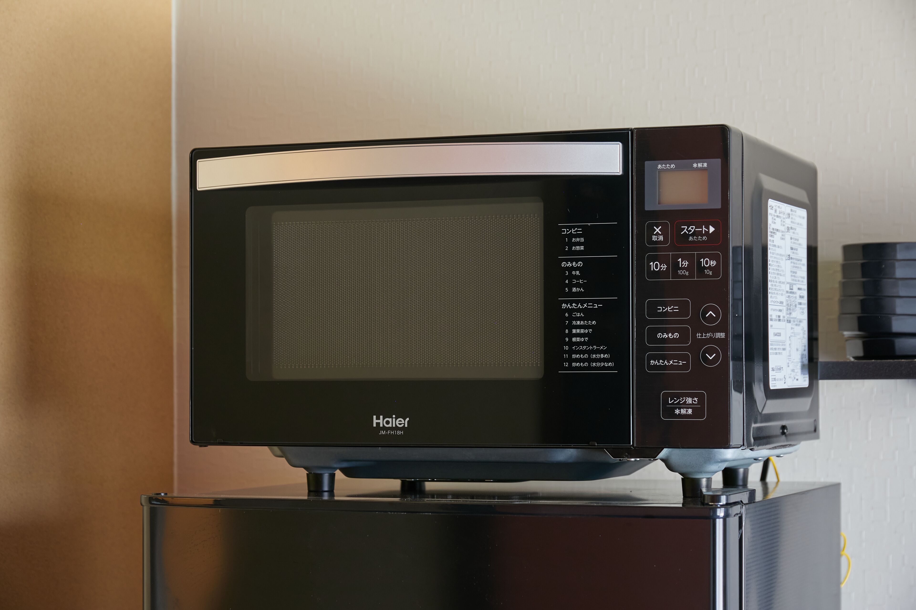A Haier microwave oven placed on a black stand.