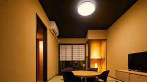Een traditionele Japanse kamer met tatami vloeren, een lage tafel en paarse stoelen.