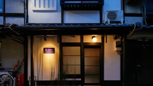 Een traditioneel Japans gebouw met een schuifdeur, een fiets geparkeerd voor de deur, en een bordje dat wijst op een ruimte voor traditionele therapie.
