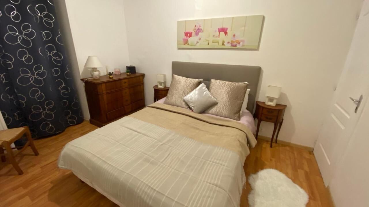 Ein Schlafzimmer mit Bett, Nachttisch, Kommode, Stuhl und einem Bild an der Wand.