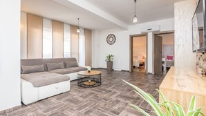 A modern living room with a sectional sofa, a round coffee table, and a wooden reception desk. - Villa M&M (Pakostane)