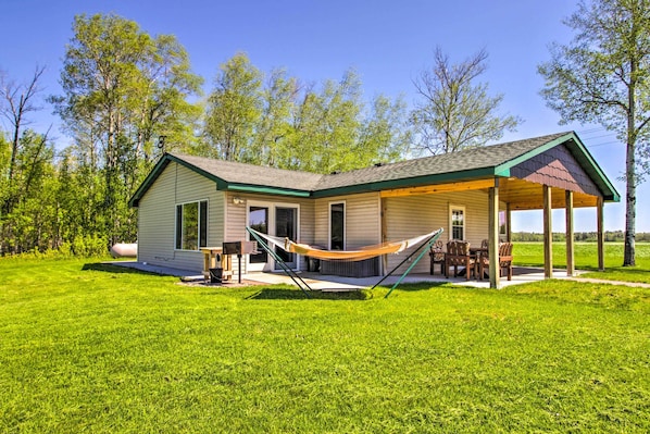 A single-story house with a covered porch and a hammock.