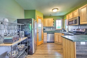 A modern kitchen with wooden cabinets, stainless steel appliances, and a built-in oven.