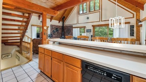 A spacious kitchen with wooden cabinets, a large island, and a dishwasher.