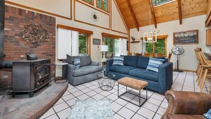 A spacious living area with a fireplace, sofas, and a dining area.