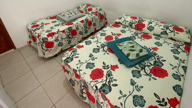 A room with two beds, each covered with floral bedding. - Hotel Santa Clara (Belém)