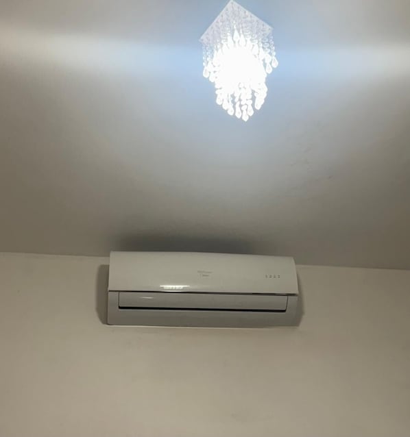 A ceiling-mounted air conditioner in a room with a plain white ceiling and walls. - Hotel Santa Clara (Belém)