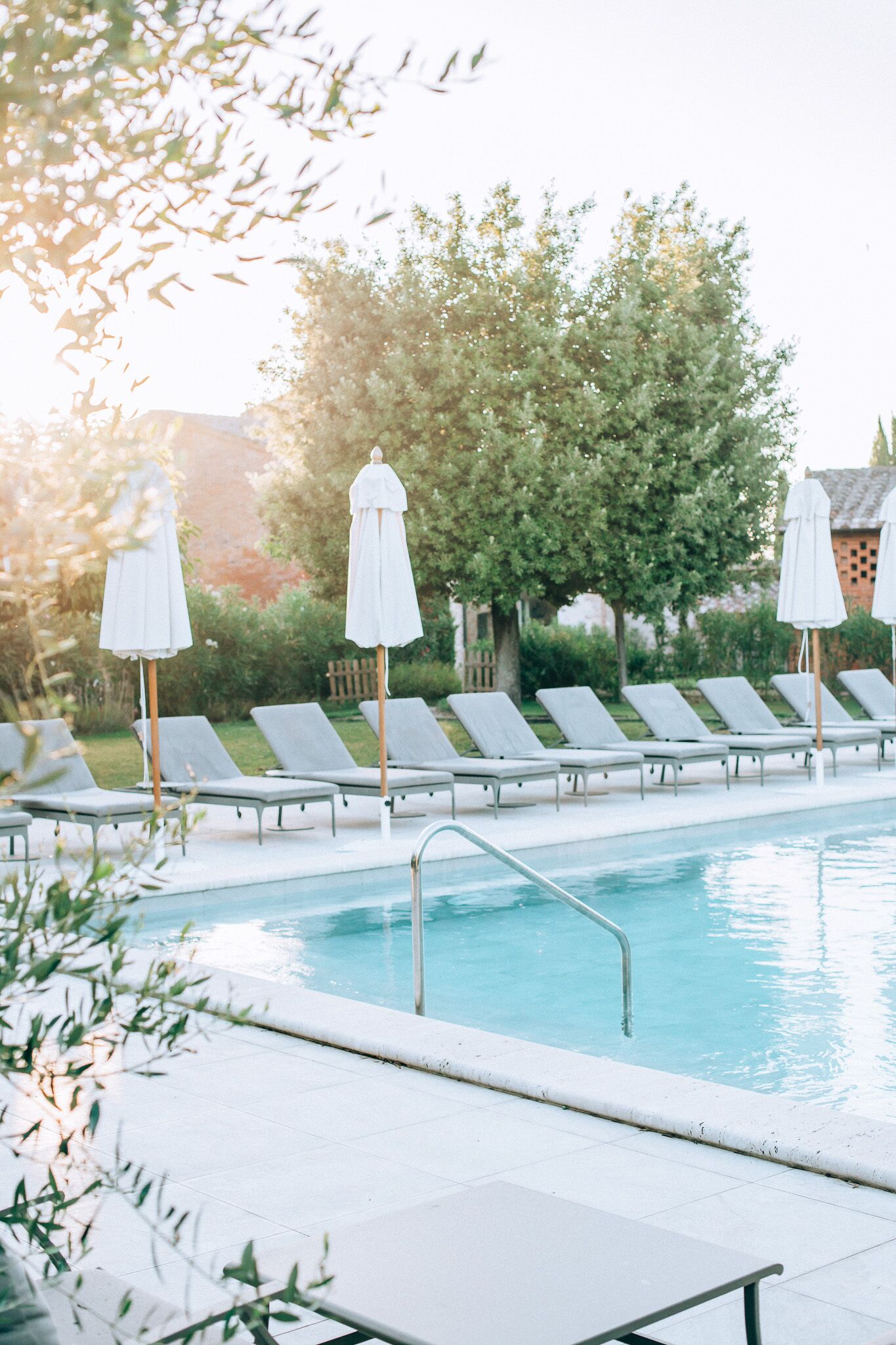 Un espace piscine équipé de chaises longues et de parasols.