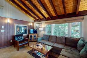 Relax in this inviting living room with a large sofa, coffee table, and wall-mounted TV.