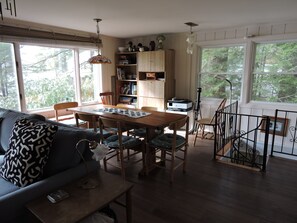Un salon chaleureux avec une table à manger en bois, des chaises, un canapé et une bibliothèque.