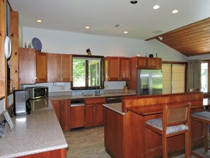 Enjoy cooking in this well-equipped kitchen with a central island, refrigerator, microwave, and dishwasher.