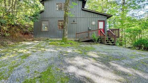 Eine rustikale Holzhütte mit Kiesweg, umgeben von dichtem Wald.
