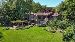 Une maison à deux étages dotée d’un patio couvert et d’un escalier menant à l’entrée.