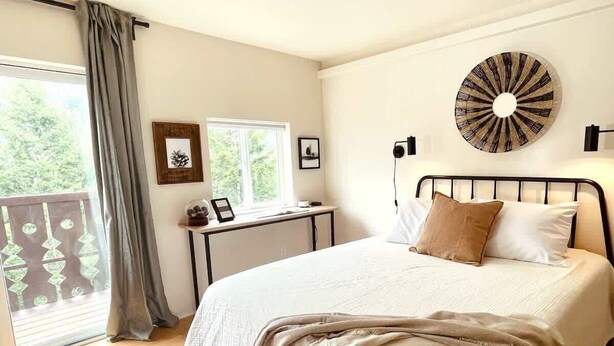 Una camera da letto con un letto, una scrivania e un'ampia finestra.