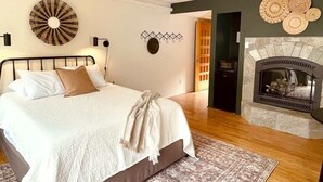 Una camera da letto con un letto, un caminetto e un orologio a parete.