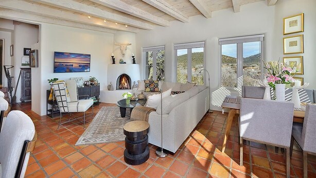 Un amplio salón con chimenea, ventanas grandes y vistas al exterior.