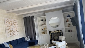 A modern living room with a dark blue sofa, a glass coffee table, and a fireplace. - Villa Zecca, Taormina (Taormina)