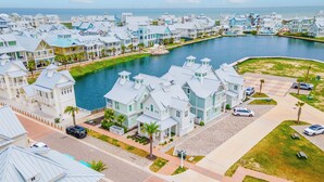 A coastal residential area with waterfront properties, paved streets, and a marina. - Five O'clock Somewhere 205 Fiv-e (Port Aransas)