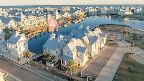 A coastal residential area with white houses, a marina, and a calm body of water. - 5 O'clock Four Shore 205 Fiv-f (Port Aransas)