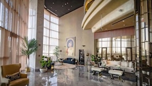 A spacious lobby with a high ceiling, large windows, and a polished marble floor. - Paramount Towers 2BR Luxurious Apartment - 360 vacation (Dubai)