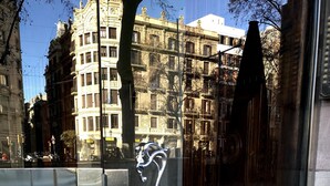 Entrada d'un edifici modern amb una porta de vidre i un mànec metàl·lic.