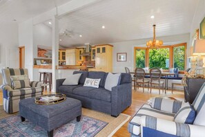 A spacious living area with a sofa, armchairs, and a coffee table.