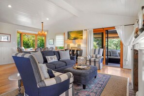 A living room with a sectional sofa, armchairs, a coffee table, and a fireplace.
