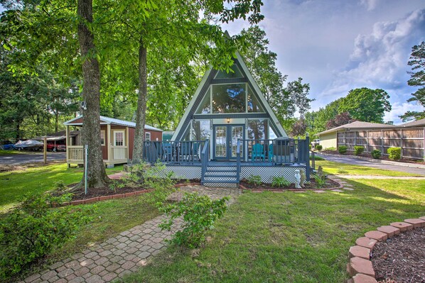 Situated in a residential area, this charming home features a porch with a seating area and a well-manicured lawn.