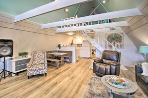 Stylish living area with a central staircase, dining bench, and leather armchair.