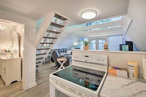 Enjoy cooking in the kitchen with an oven and stovetop, then dine in the adjacent area with a sofa and small table.