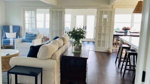 Un salón amplio con un gran sofá seccional beige, una mesa de centro y un comedor con sillas de madera y una mesa.