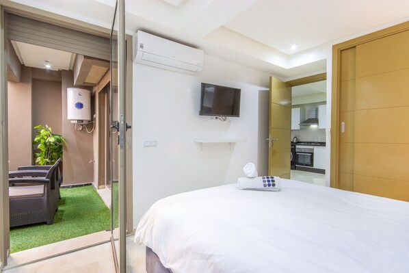 A hotel room with a bed, a TV mounted on the wall, a water heater, and a small kitchenette. - NEW! Plein Gueliz, wifi, terrace (Marrakech)