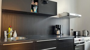 A modern kitchen with a built-in oven, a coffee maker, and a toaster. - Modern holiday flat with comfortable furnishings, quiet and centrally located (Weimar)